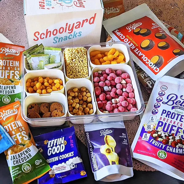 Schoolyard Snacks box surrounded by protein puffs, cookies, and keto-friendly snacks.